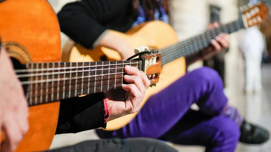 close up of a boys hand playing the guitar
